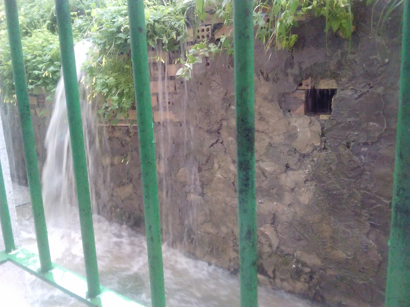 Cascada en la que desemboca el agua de lluvia en el patio de la vivienda de Picadueñas afectada por la falta de alcantarillas.