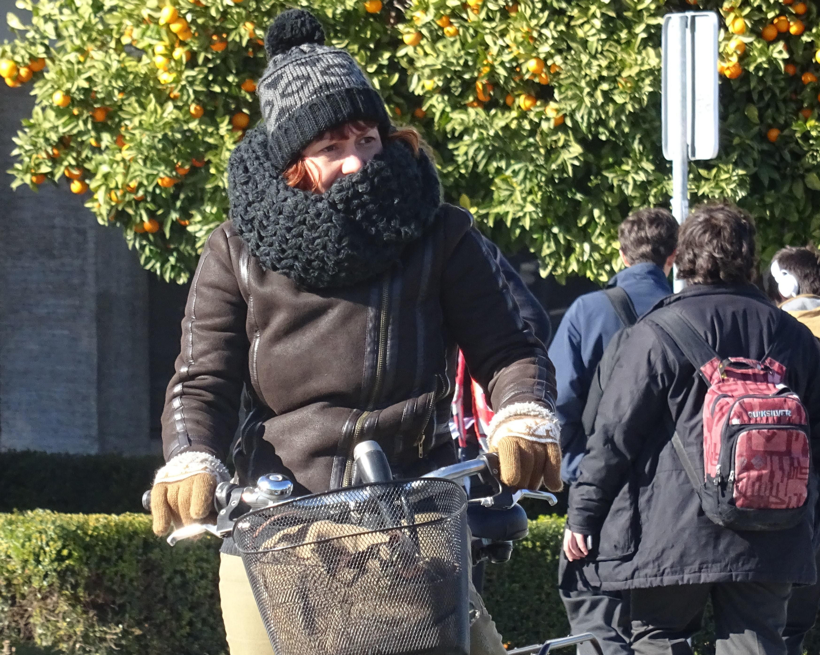 Una mujer se protege del frío con bufanda y guantes.