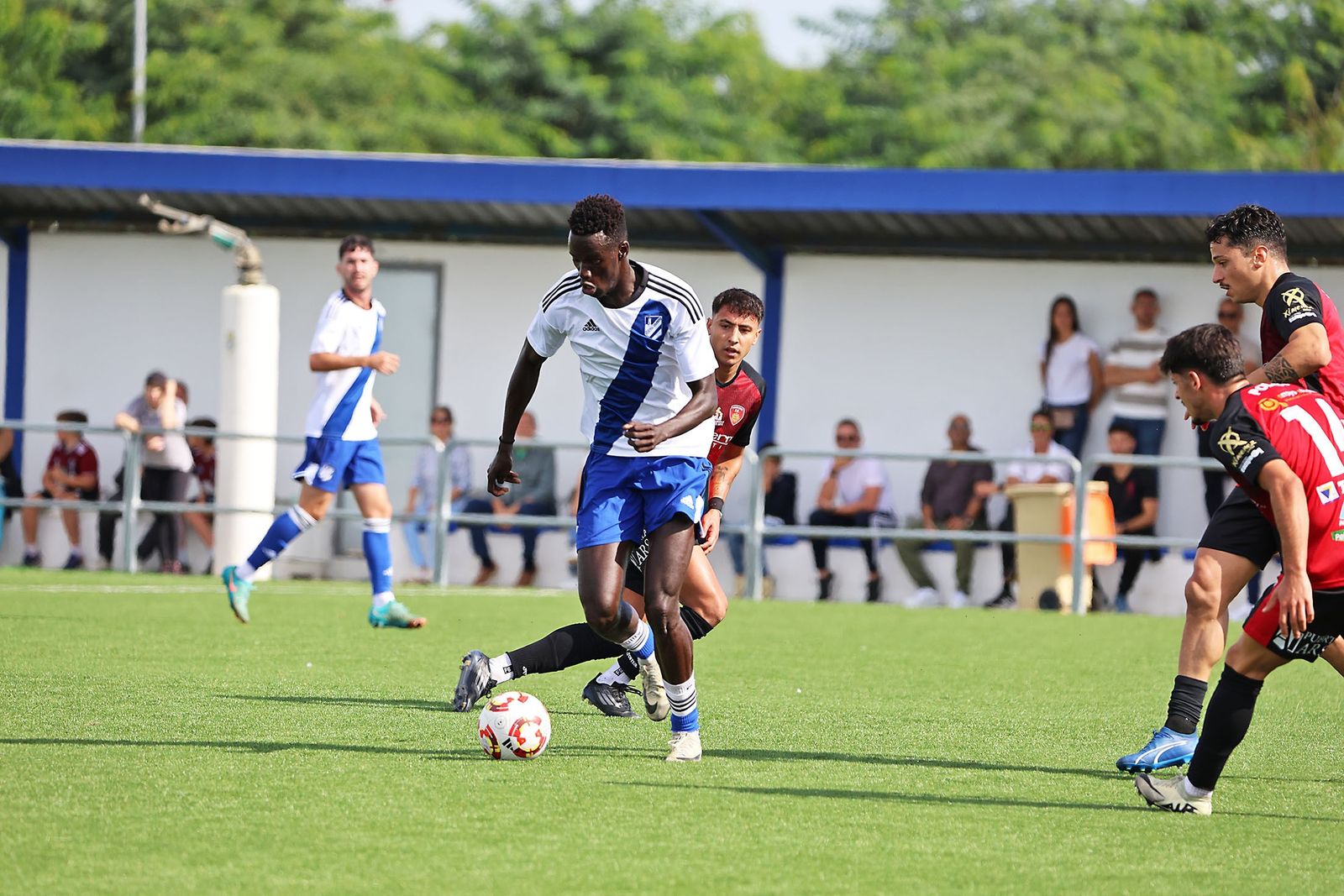 Cheikh controla el balón bajo la mirada de tres rivales.