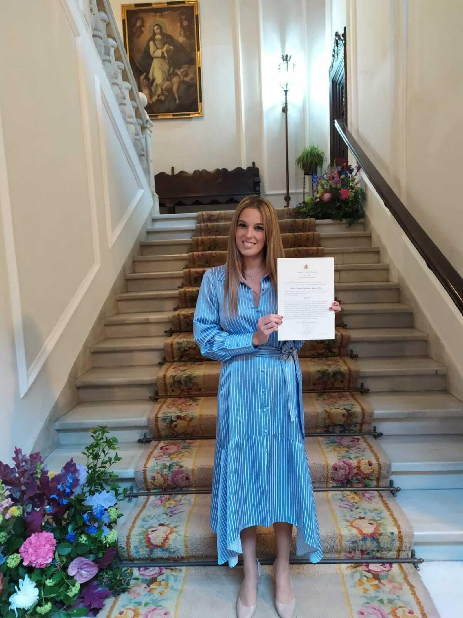 Carmen Epifanía Baena muestra su título.