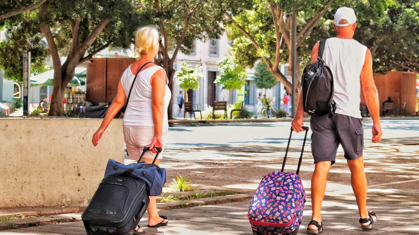 Turistas con maletas alejándose del Centro de la capital
