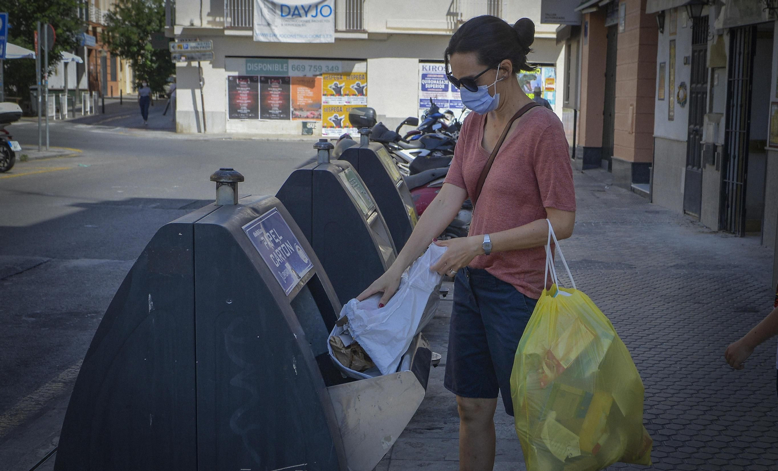Una ciudadana deposita la basura en un contenedor de recogida selectiva.