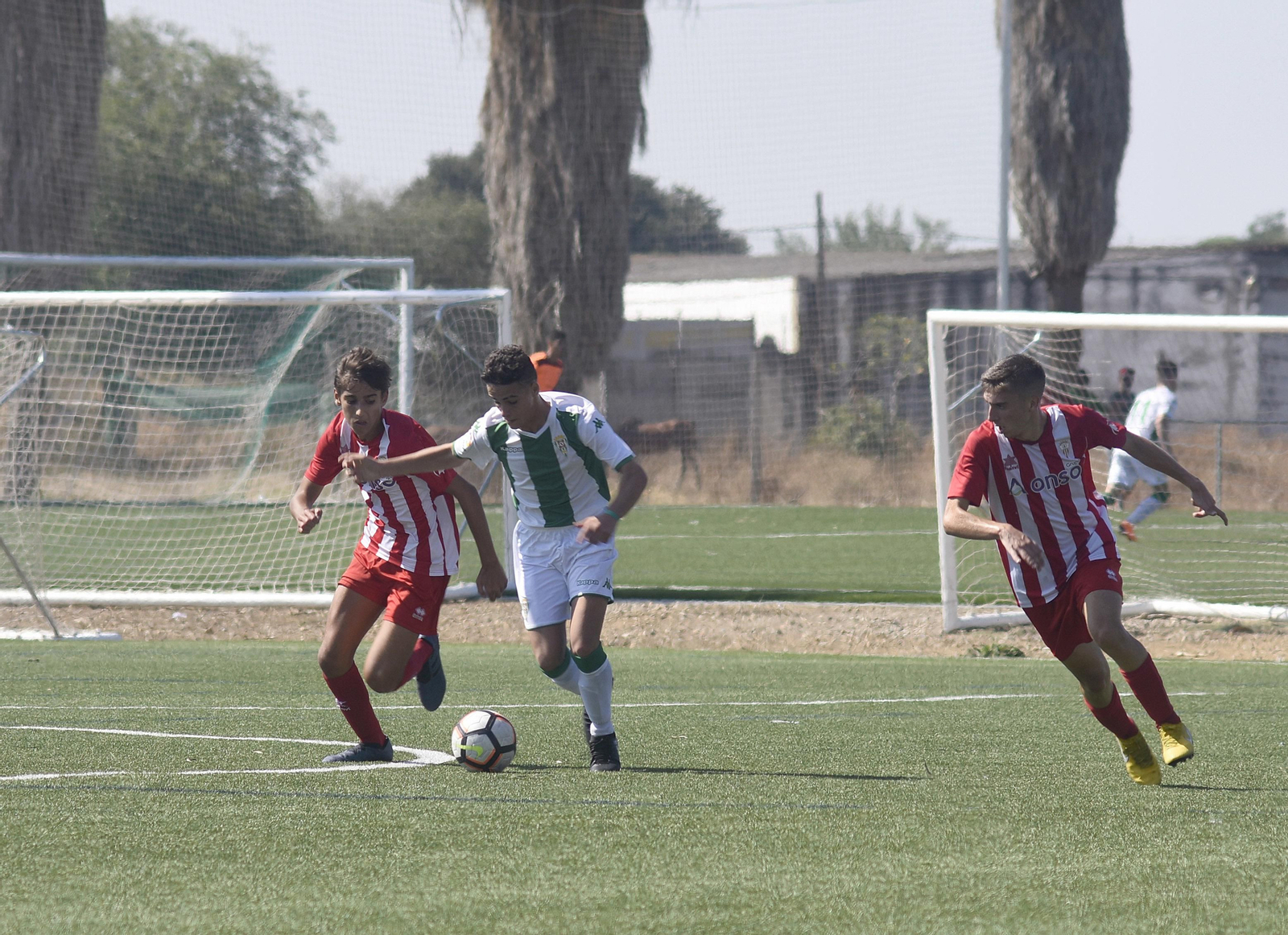 Un jugador del Córdoba de la Primera Andaluza Cadete escapa de la presión de dos rivales.