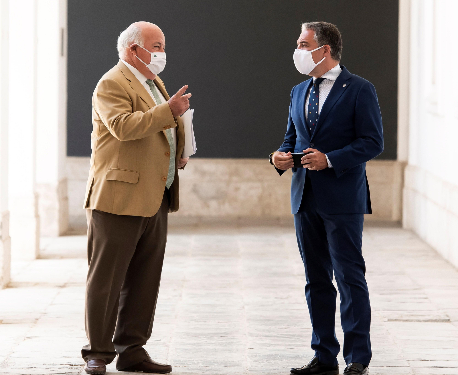 El consejero de Salud, Jesús Aguirre, conversa con el portavoz de la Junta, Elías Bendodo.