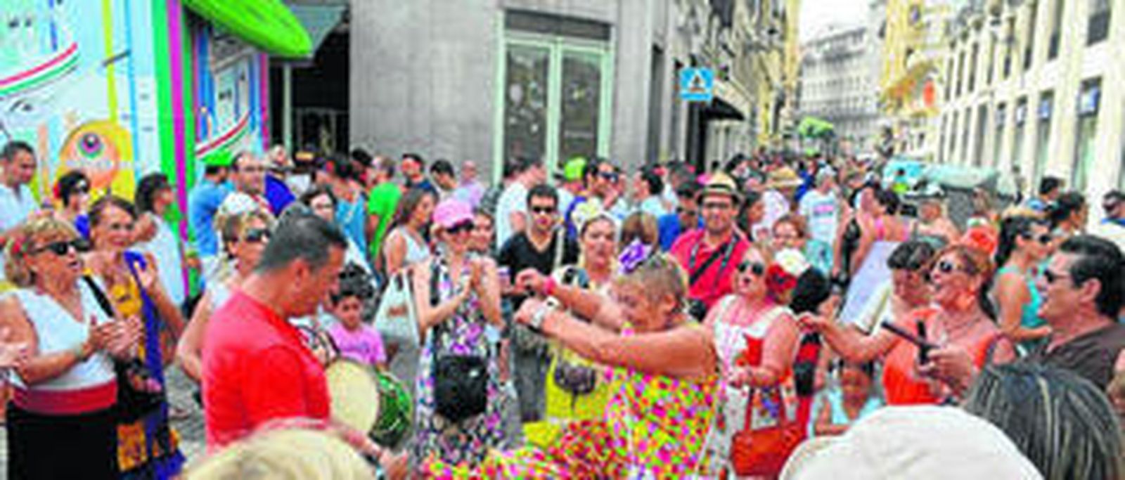 Una pareja baila sevillanas bajo la portada de la Feria en la calle Larios.