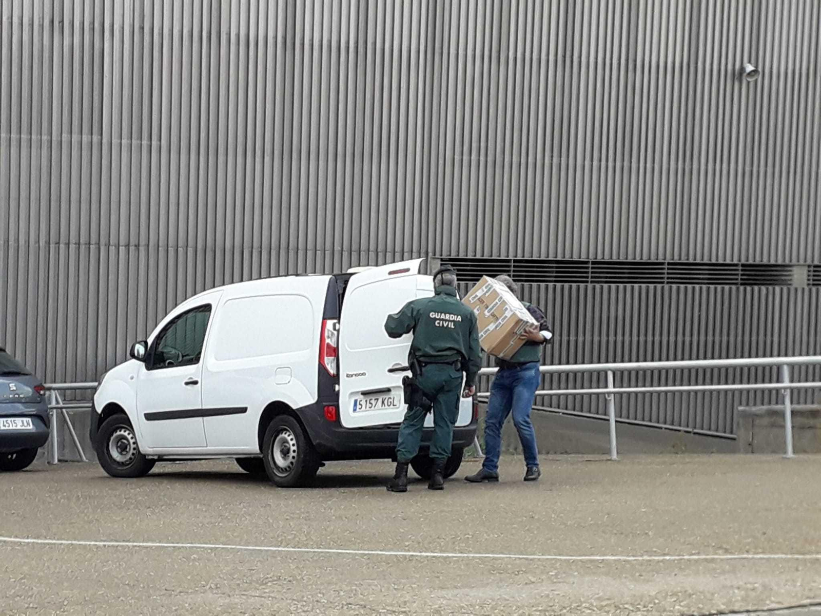 Guardias civiles introducen en una furgoneta la documentación requisada