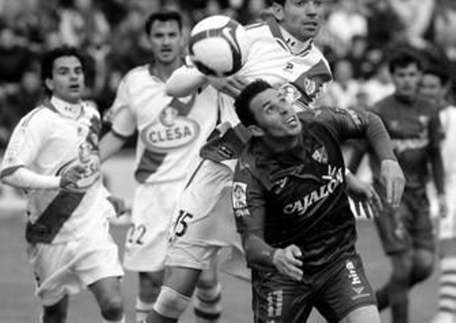 Rubén Castro, delantero del Huesca, intenta llegar a un balón de cabeza ante la oposición del rayista Salva.