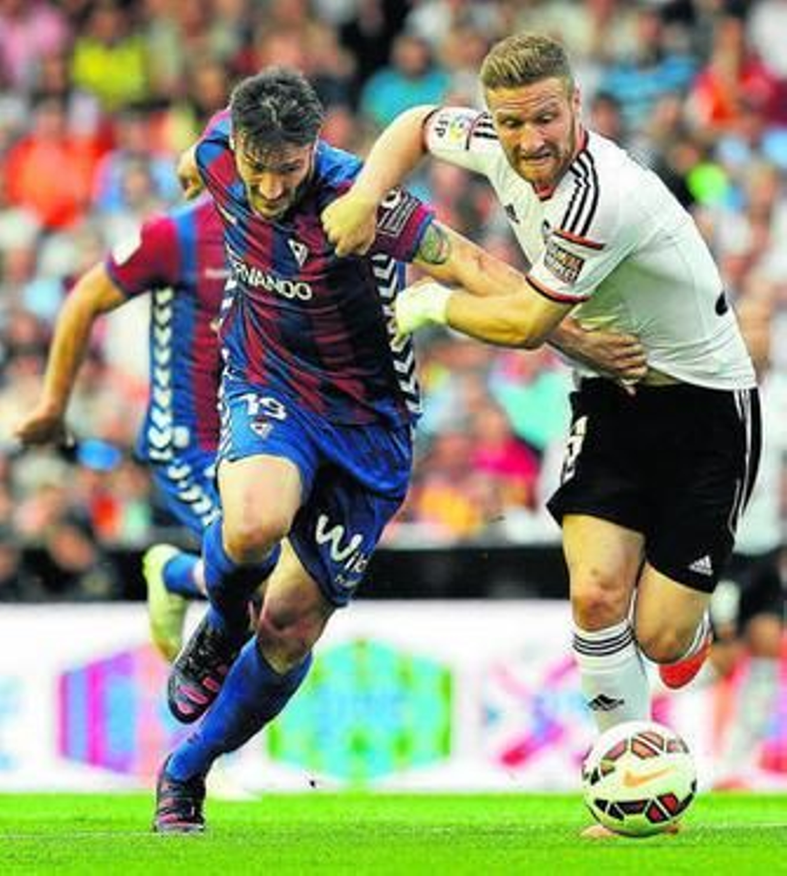 El defensa del Valencia Mustafi pugna con el delantero visitante Piovaccari.