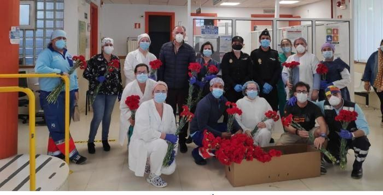 Policías y personal sanitario de la residencia tarifeña, junto a las flores