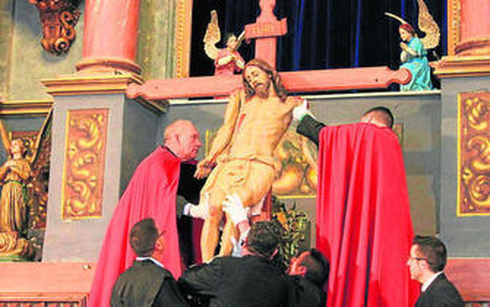 Los hombres de capa roja realizan la crucifixión.