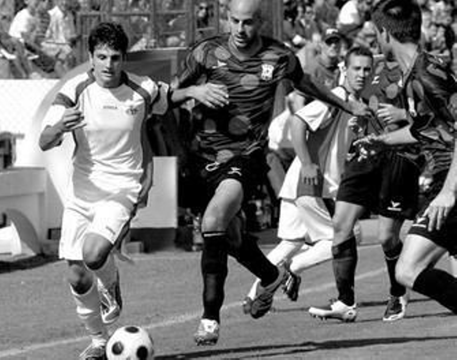 Carlitos (i) avanza con el balón en un encuentro de la presente temporada.