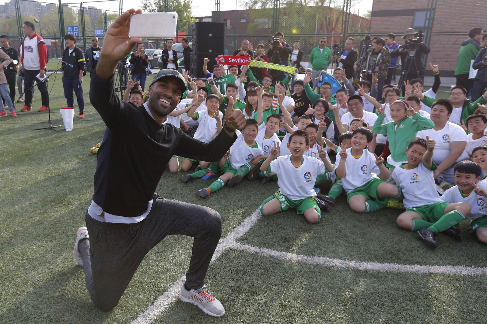 Kanoute se hace un 'selfie' con los niños de un centro deportivo de Pekín.