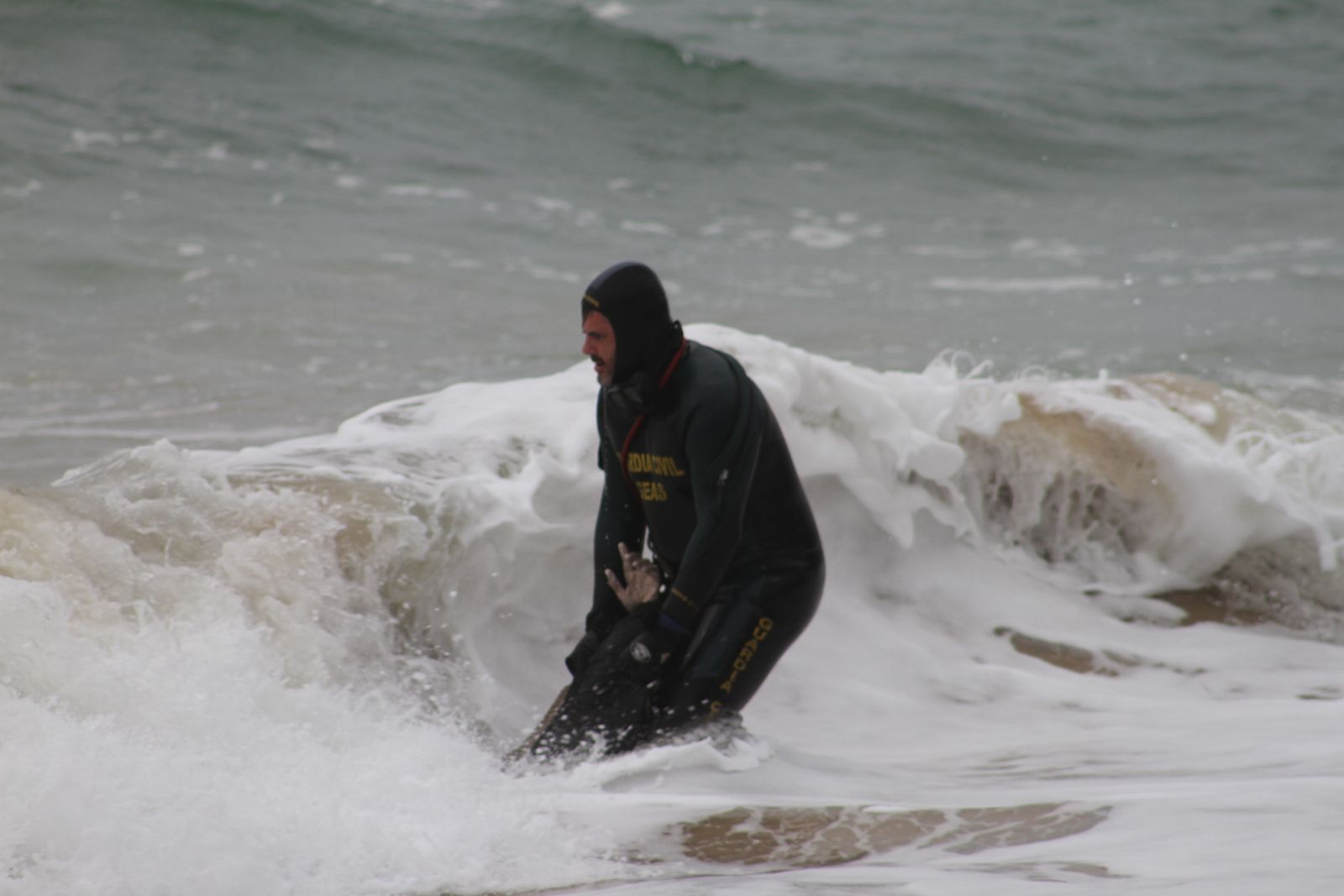 Un miembro del GEAS de Algeciras rescata un cadáver de la playa de los Caños de Meca tras el naufragio de la patera en la que perdieron la vida 23 personas.