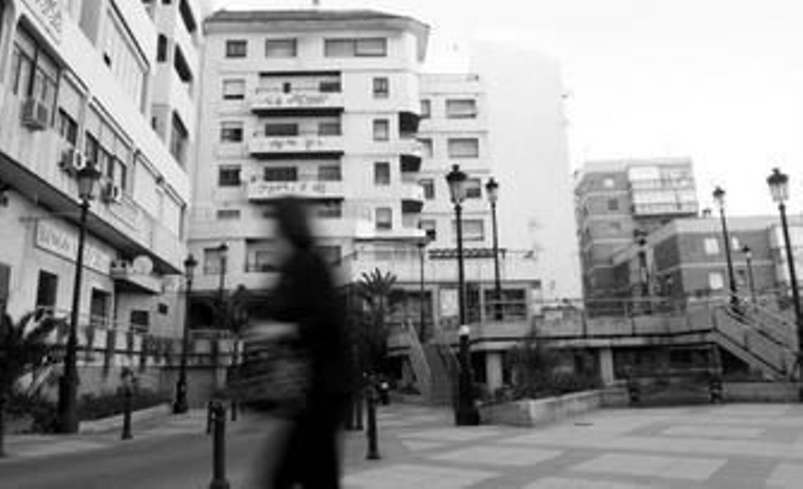 Una mujer camina por delante del edificio Escalinata, al fondo de la imagen, declarado en ruina urbanística por el Ayuntamiento.