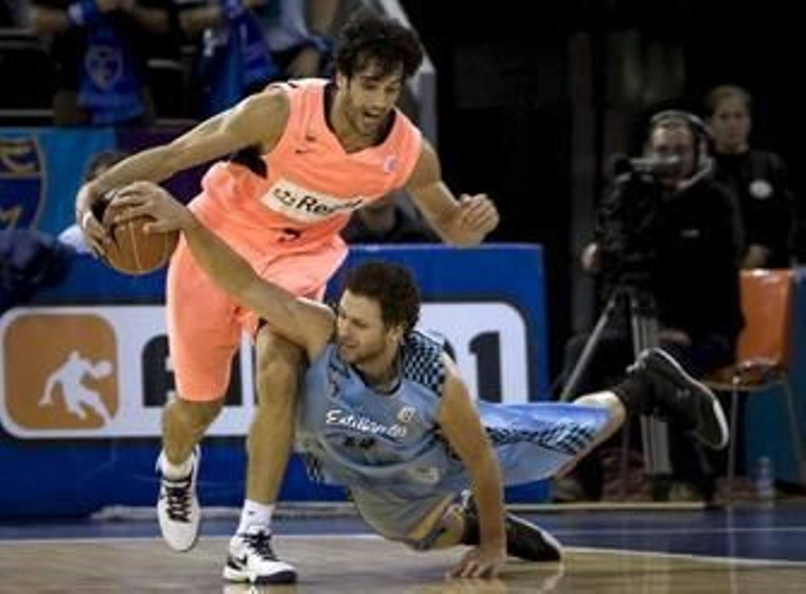 Jasen trata de arrebatarle la pelota a Basile desde el suelo.