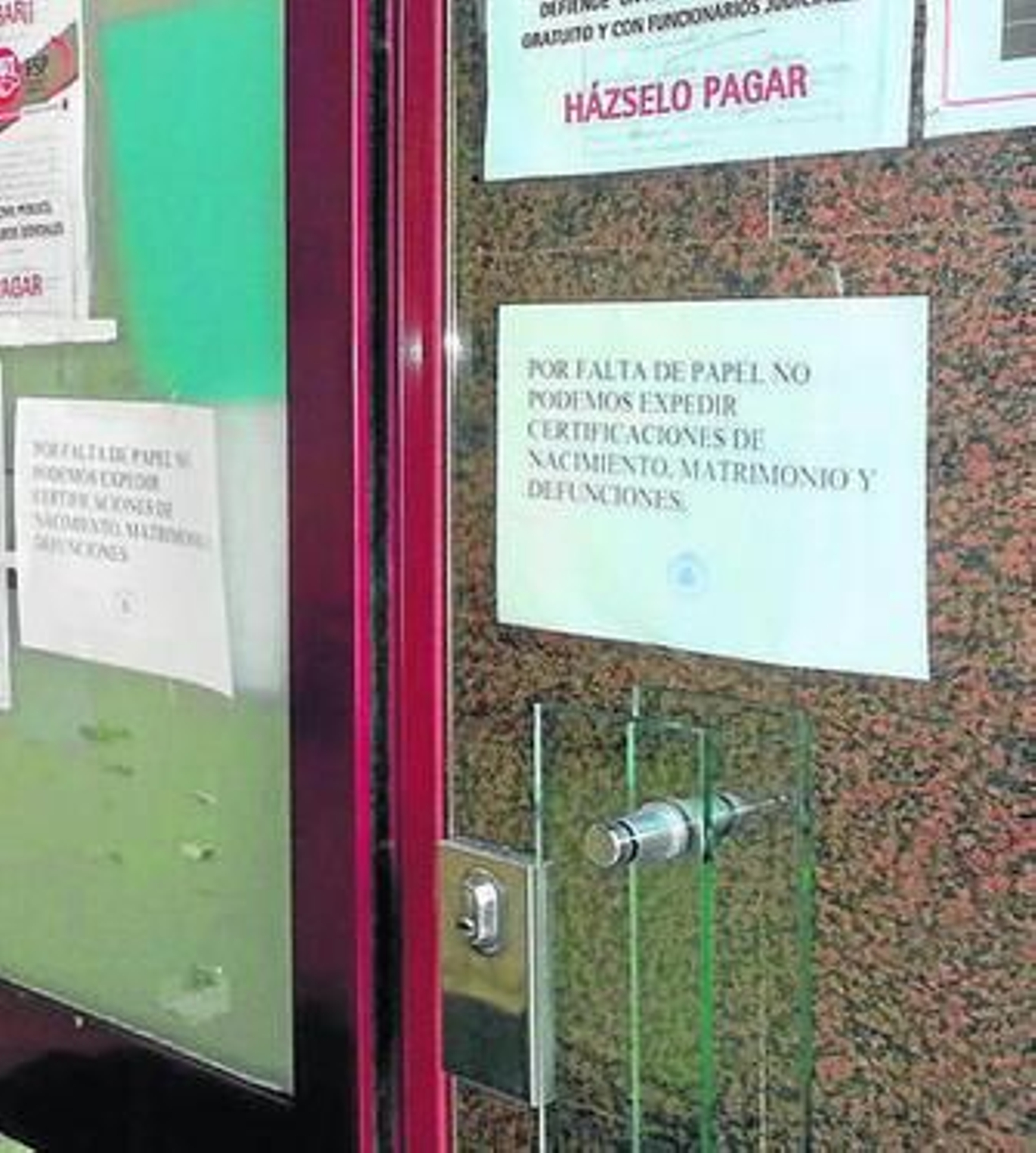Carteles informando de la falta de papel en el Registro Civil.