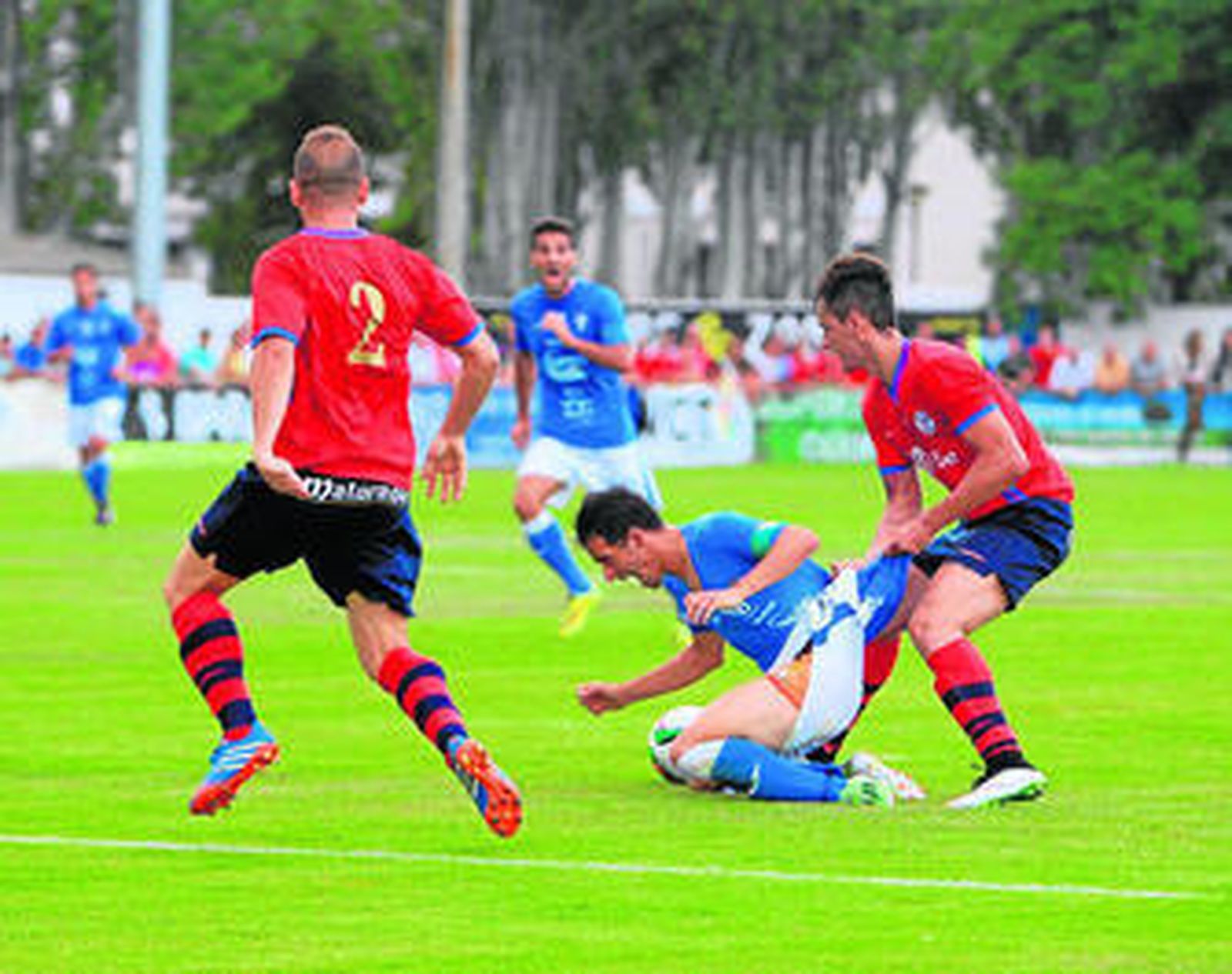 Ñoño cae al suelo agarrado por un rival, en presencia del también local Sito.