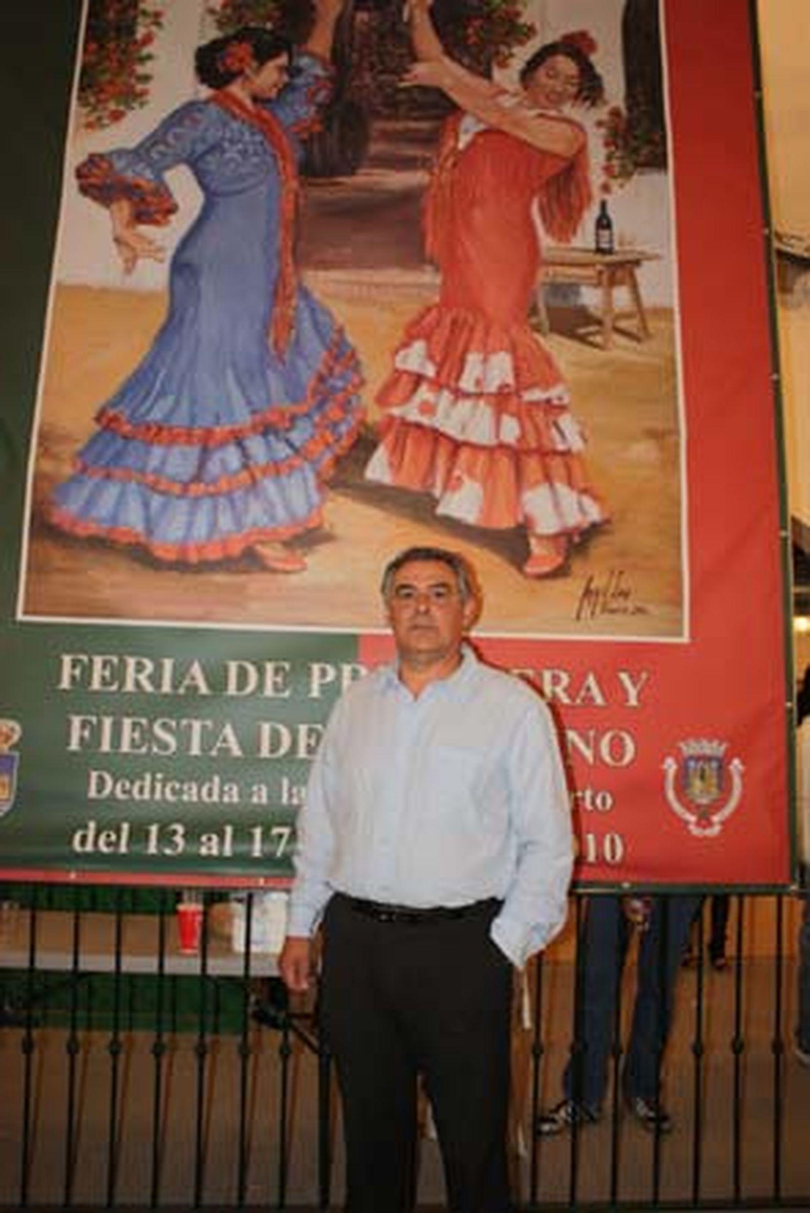 El autor del cartel de la Feria de Primavera de este año, Ángel Lara, junto a una reproducción de su obra en gran formato.

Foto: Fito Carreto