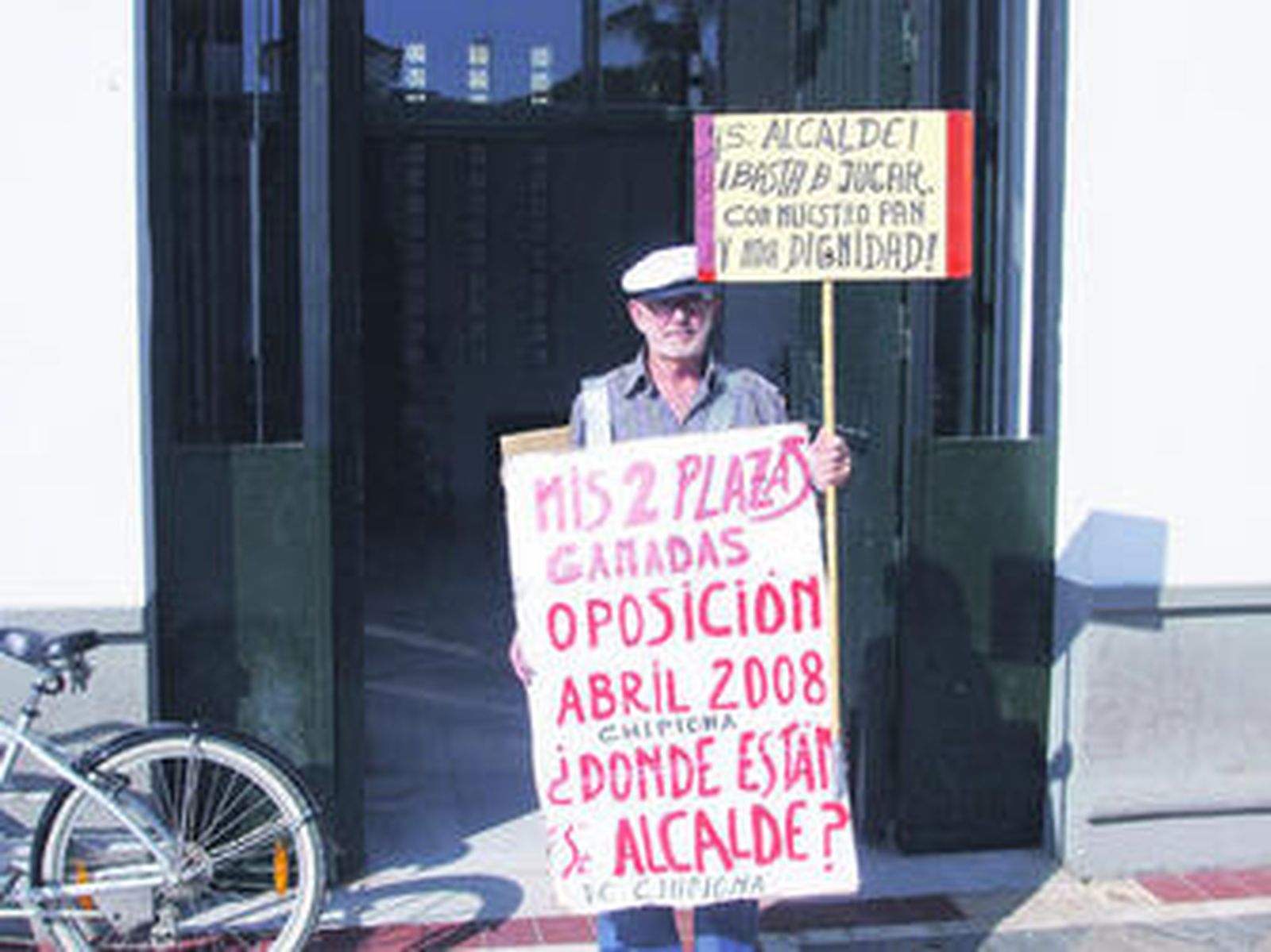 Benito Medina, protestando con carteles en una entrada del edificio municipal de la Plaza de Andalucía.