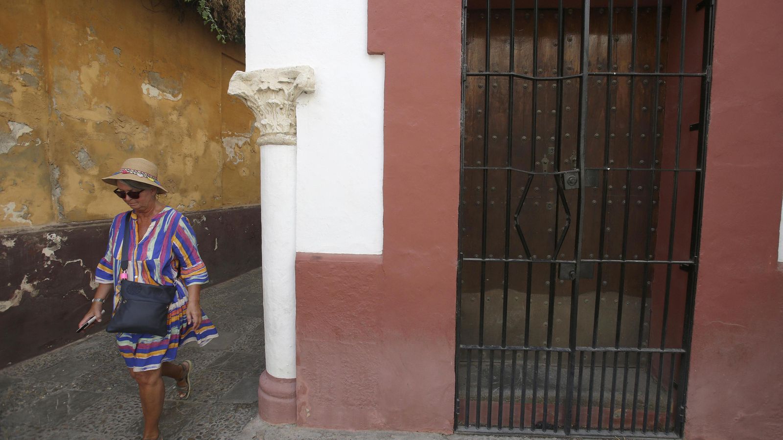 Una mujer pasea junto a una reja forzada en la calle Vida.
