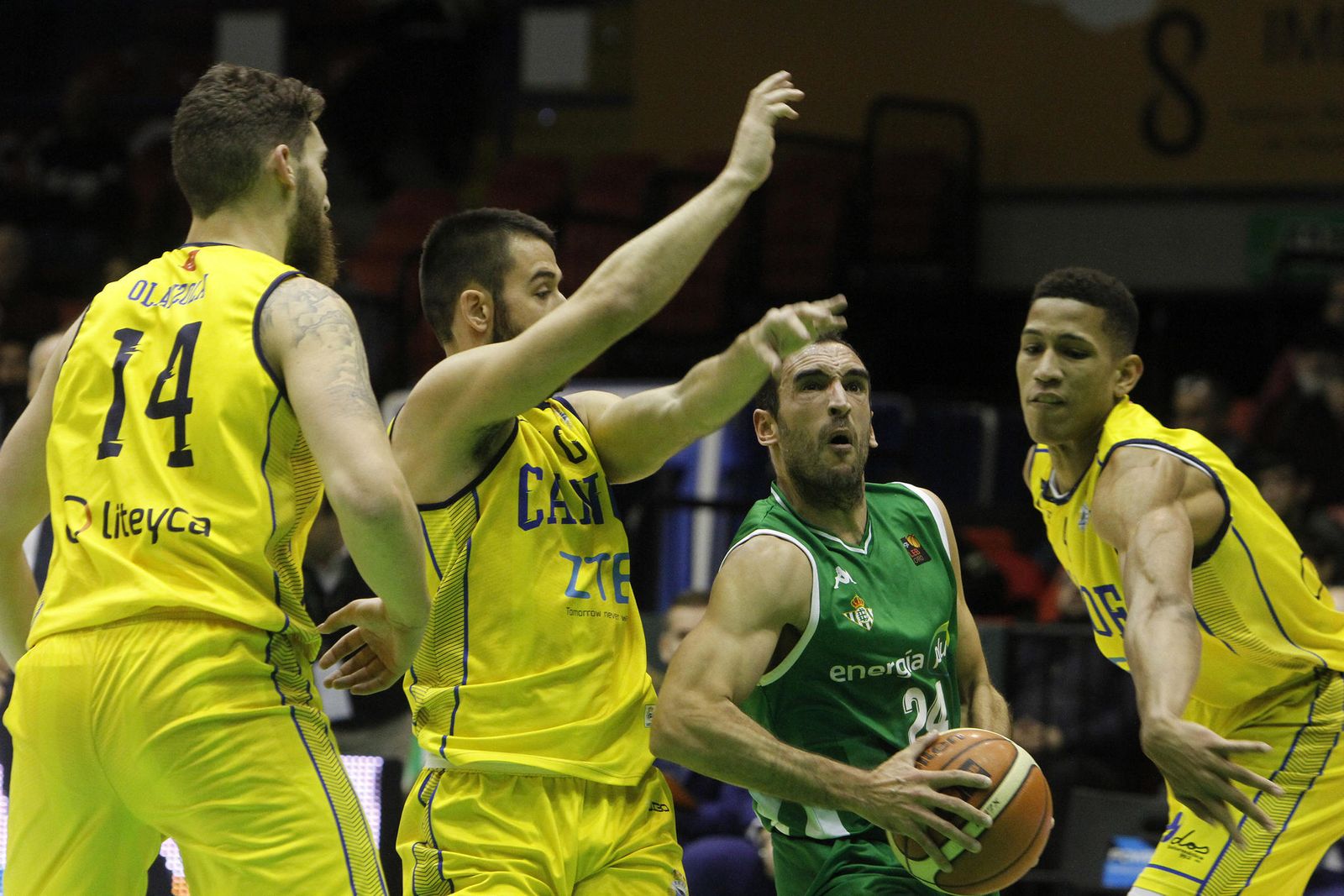 El base bético Dani Rodríguez mira el aro rodeado por tres rivales.