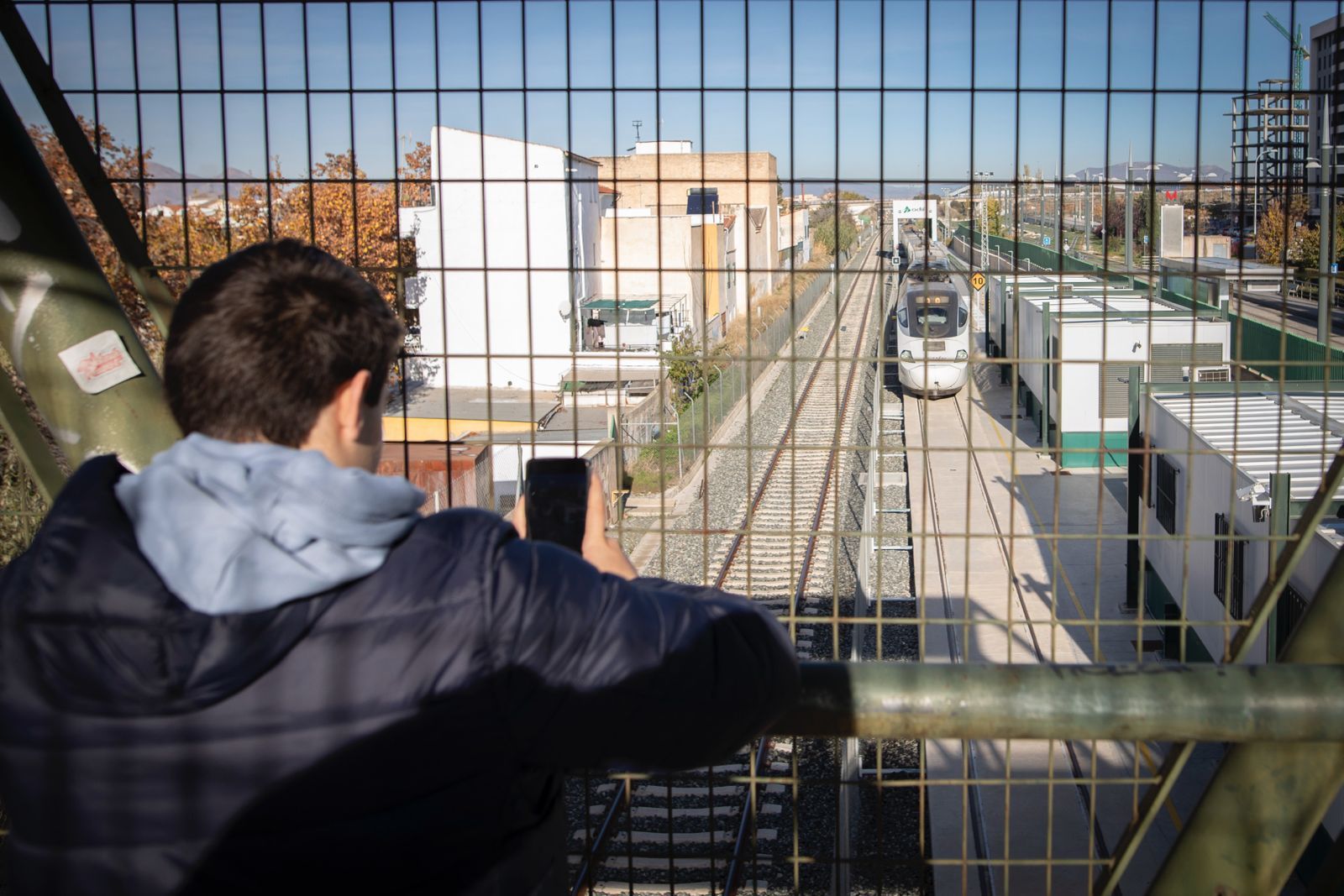 Un joven observa el paso del tren por el intercambiador de ancho en Cerrillo de Maracena