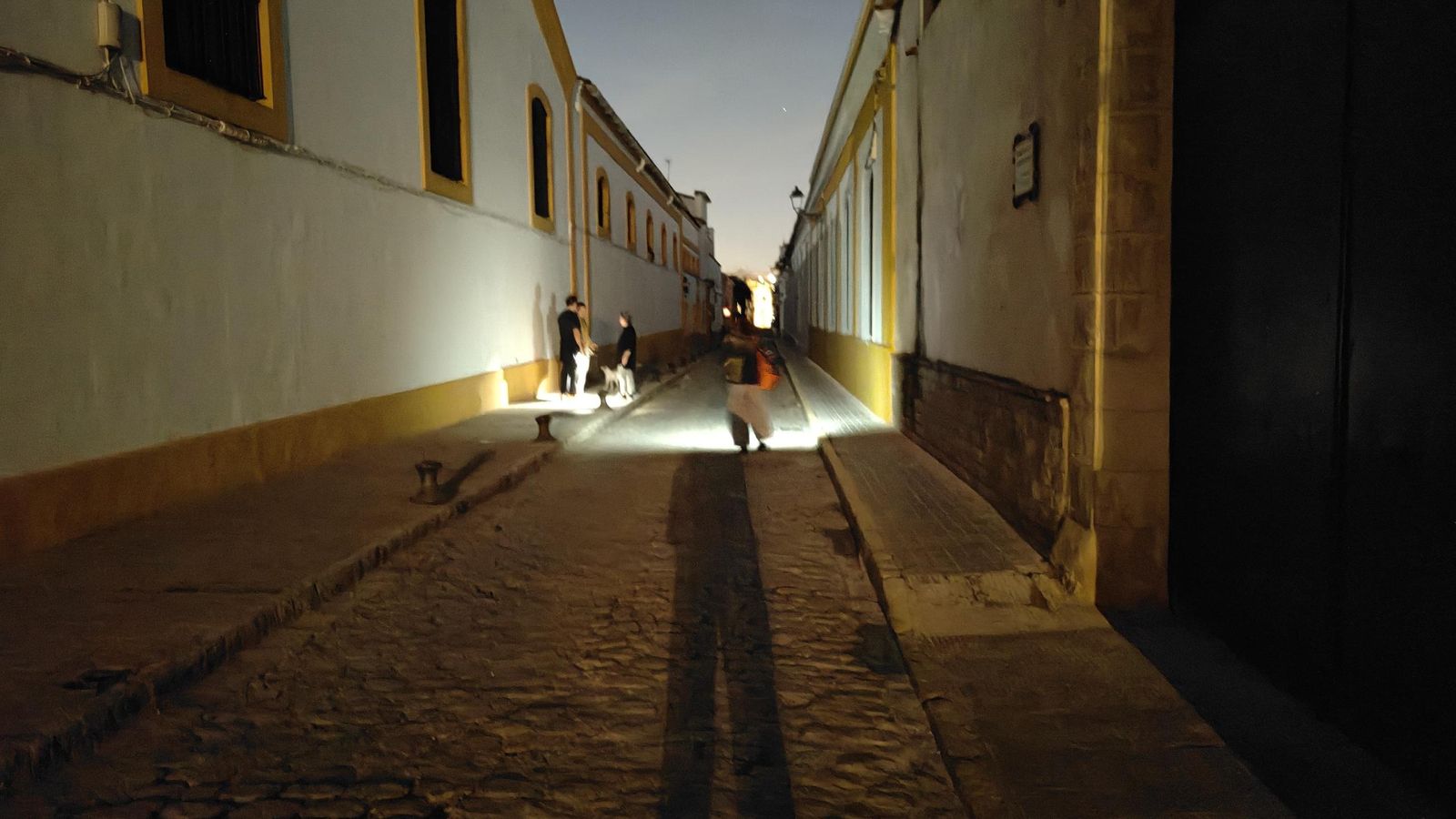 Vecinos alumbrándose en la noche del domingo con las linternas del móvil, en la calle Albareda.