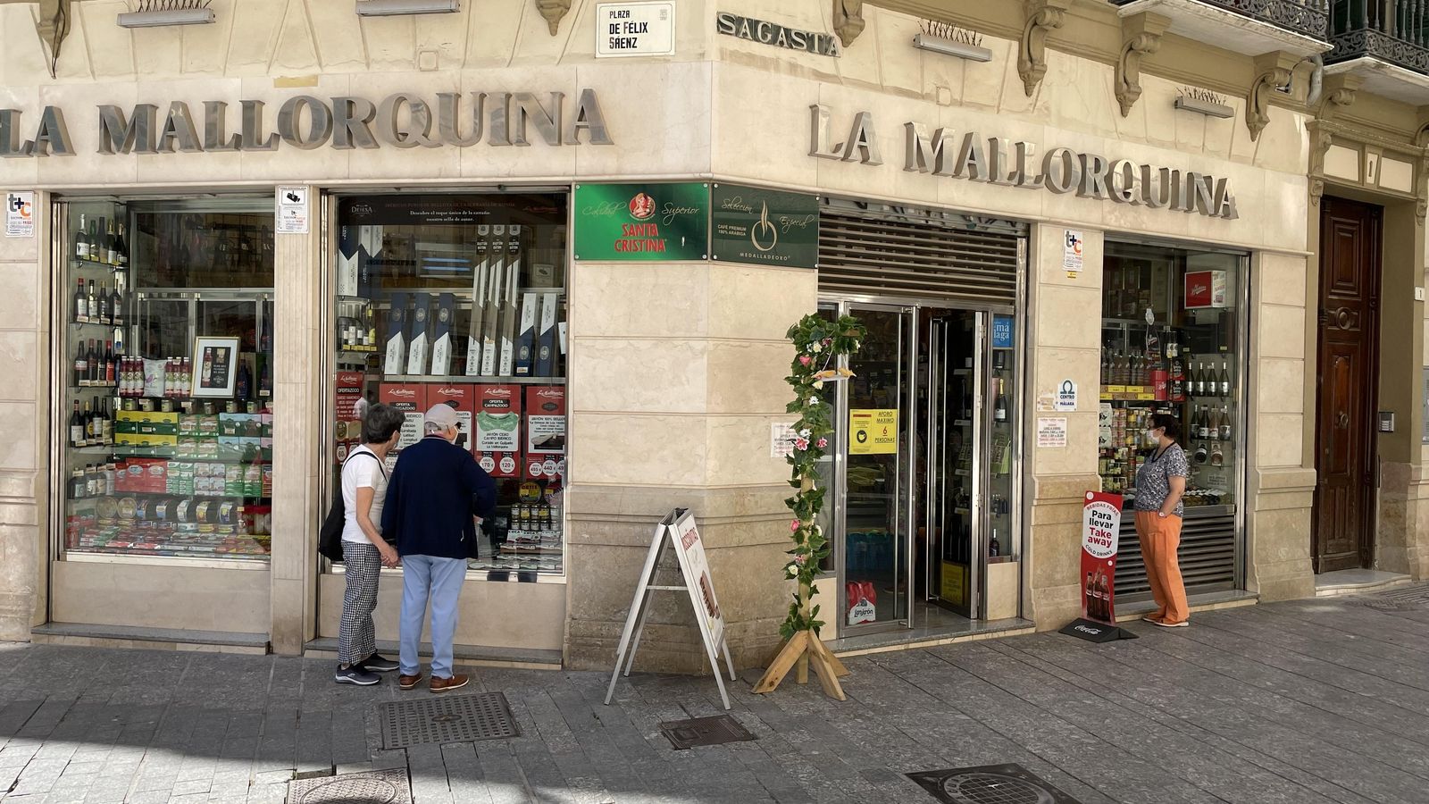 Varios clientes junto a los escaparates de los ultrmarinos La Mallorquina