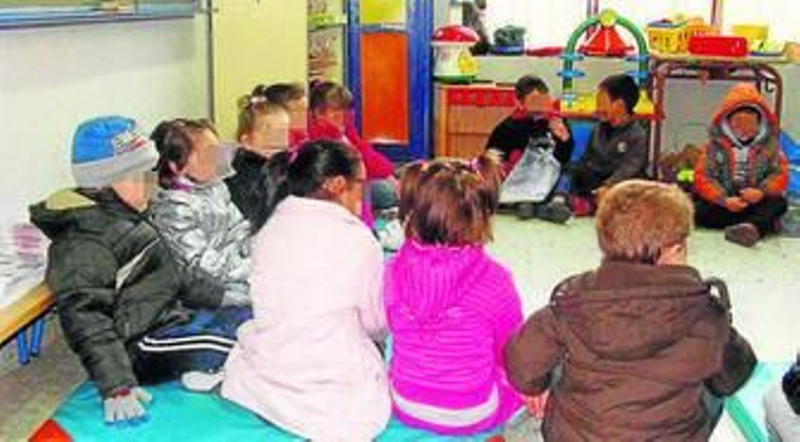 Alummnos de Infantil con abrigos en una clase.