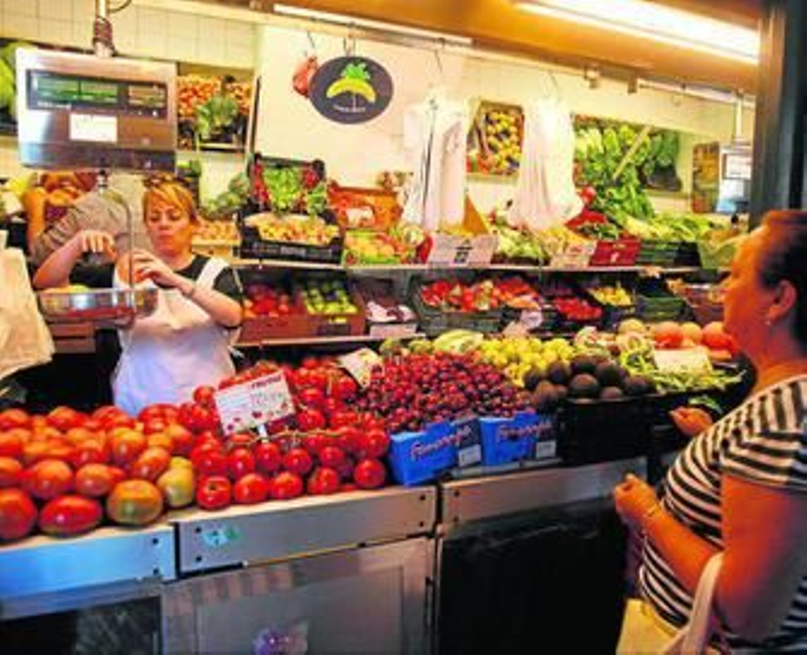 Un puesto de fruta y verdura en un mercado municipal.