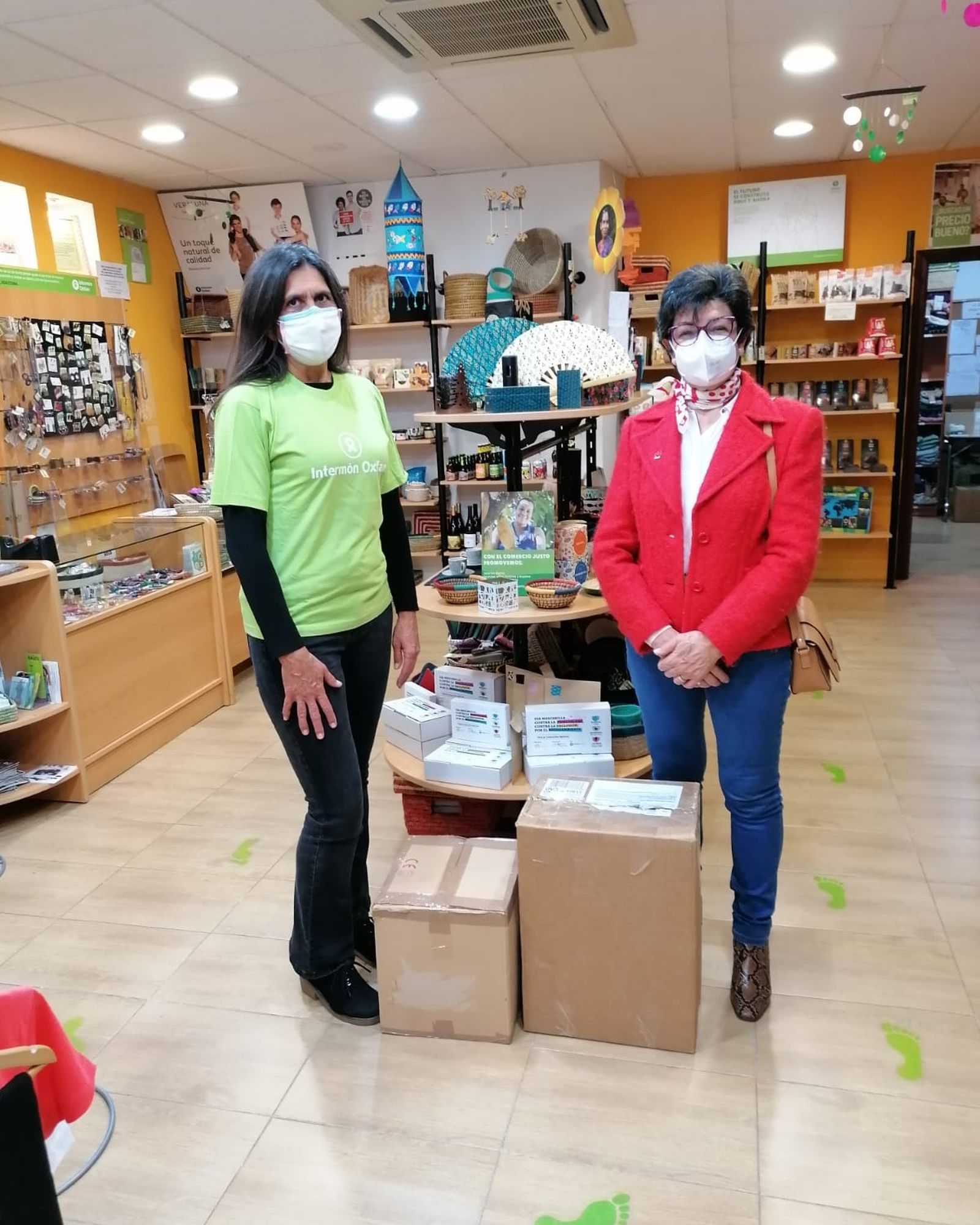 Mª Ángeles Contreras (d),  en la recogida de un lote de productos donado por voluntarios de Intermón Oxfam.