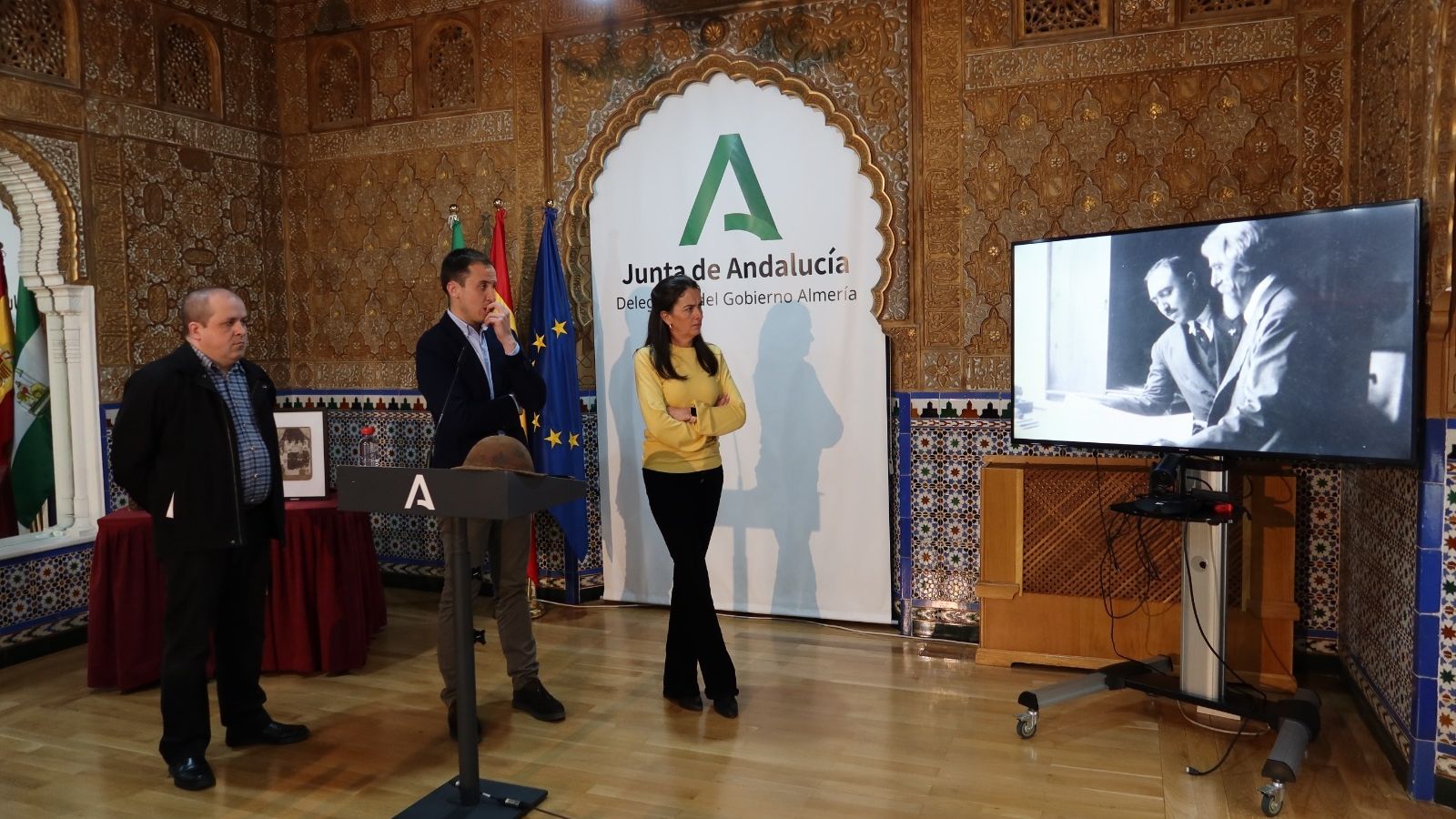 Representantes institucionales observan el vídeo promocional de la exposición.