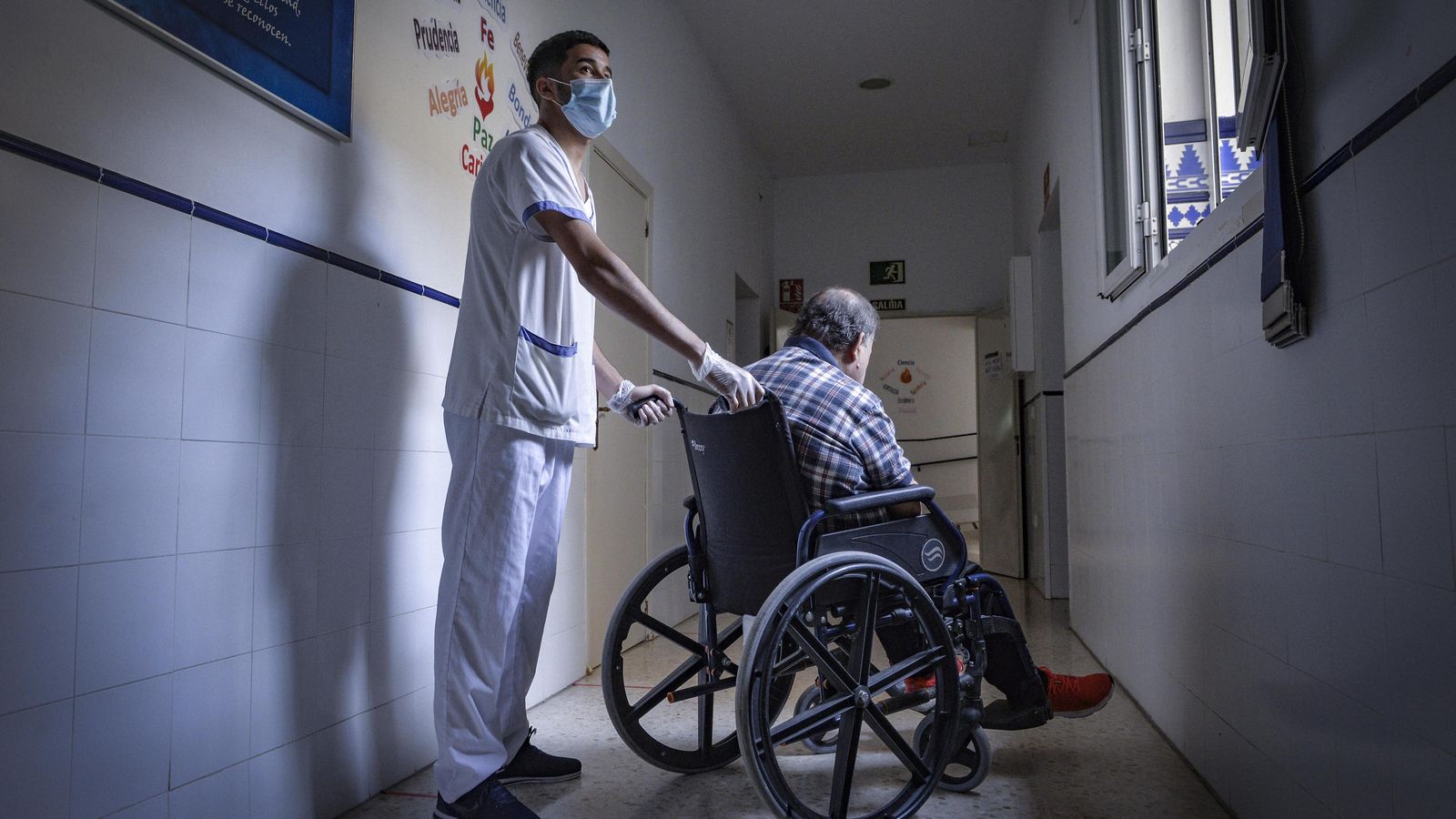 Uno de los jóvenes atiende a un hombre acogido.