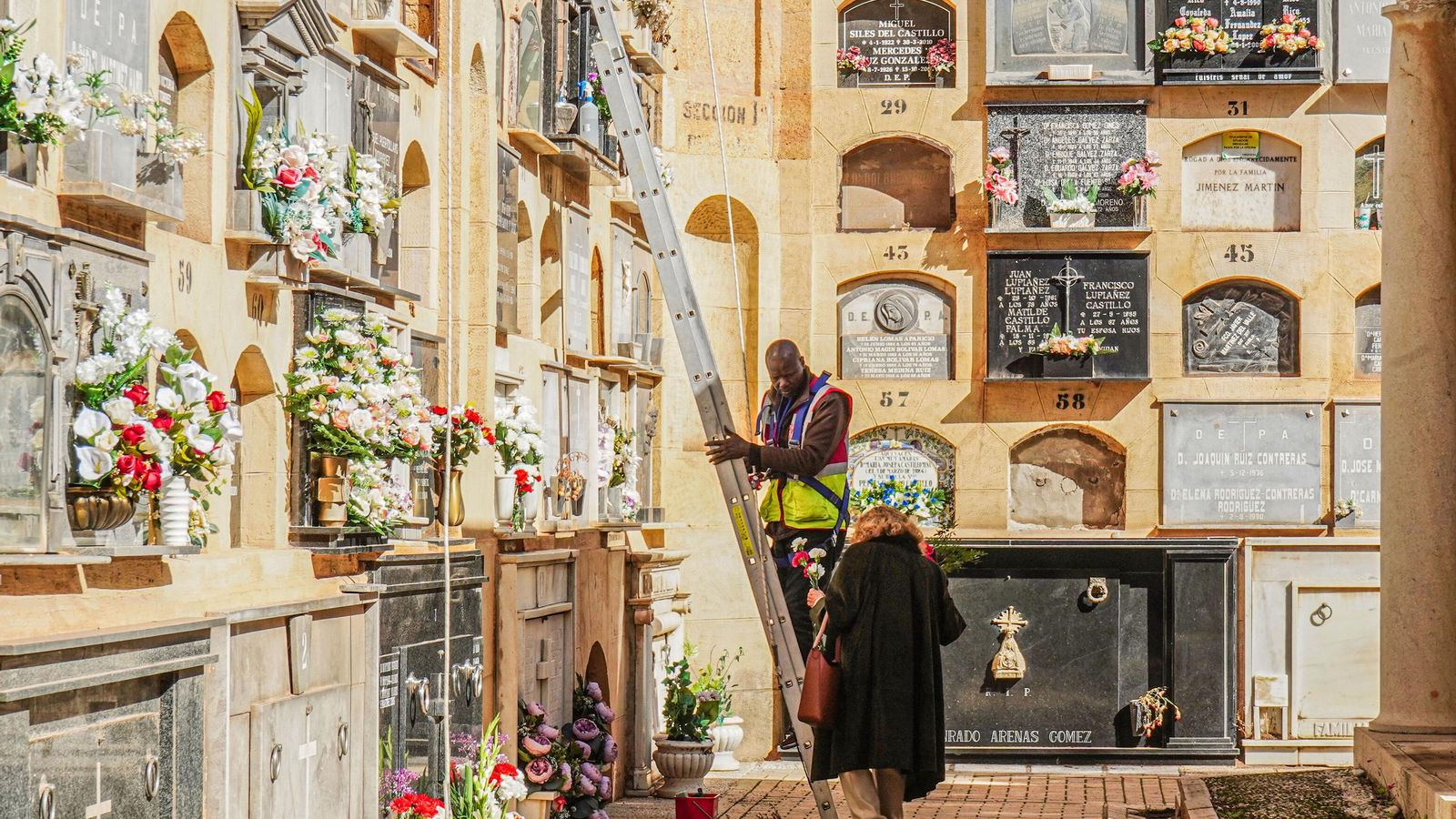 Un escalerista ayudando a una mujer.