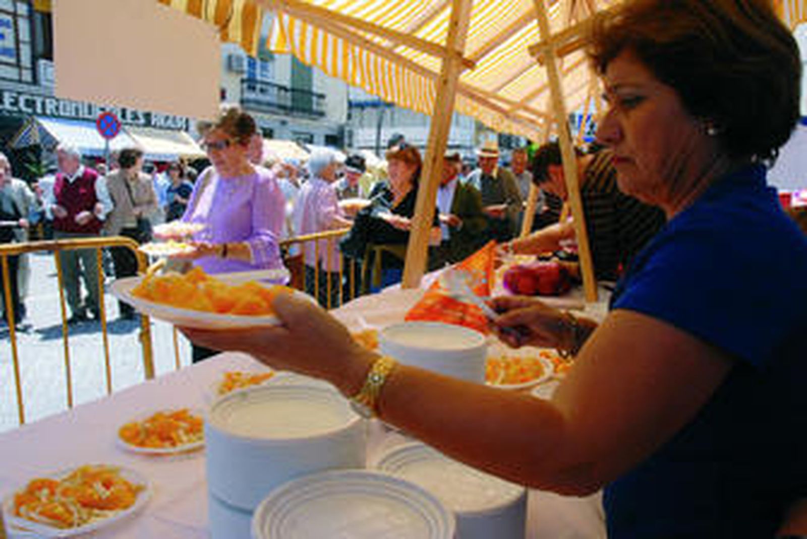 Una mujer ofrece varios platos con naranjas, ayer en Coín.