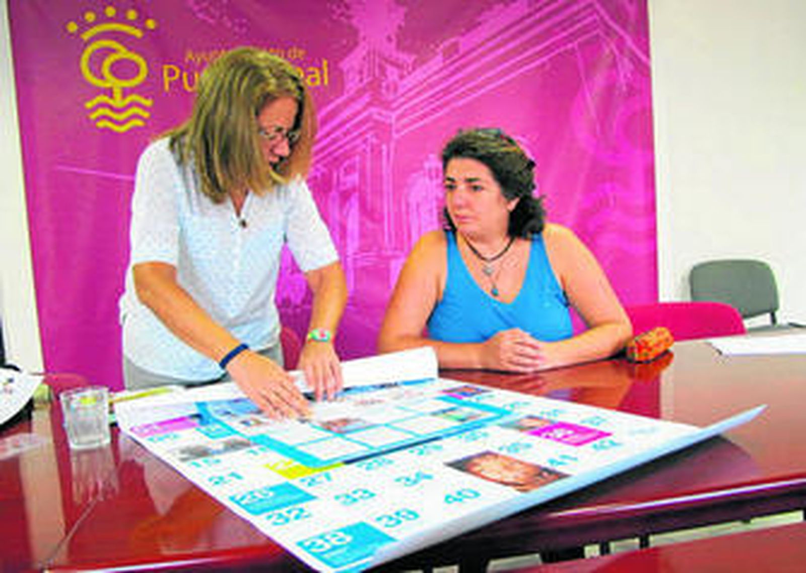 Una técnico municipal muestra a Encarna Marín parte del material que se usará en los distintos actos.