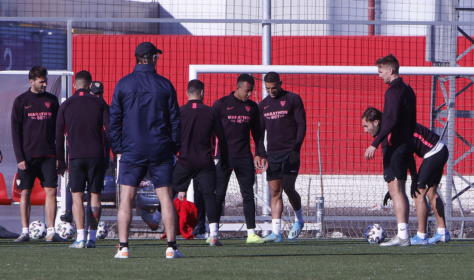 Los futbolistas del Sevilla se ejercitan sobre césped artificial ante la mirada de Lopetegui.