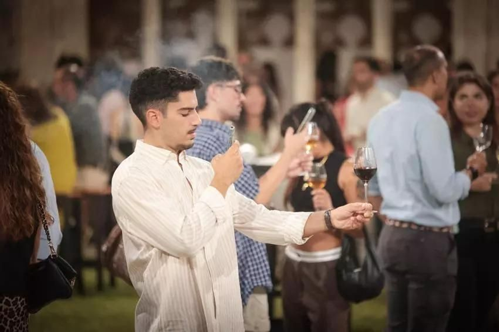Un joven fotografía una copa en un ciclo de vinos blancos y tintos de las Fiestas de la Vendimia en Jerez.