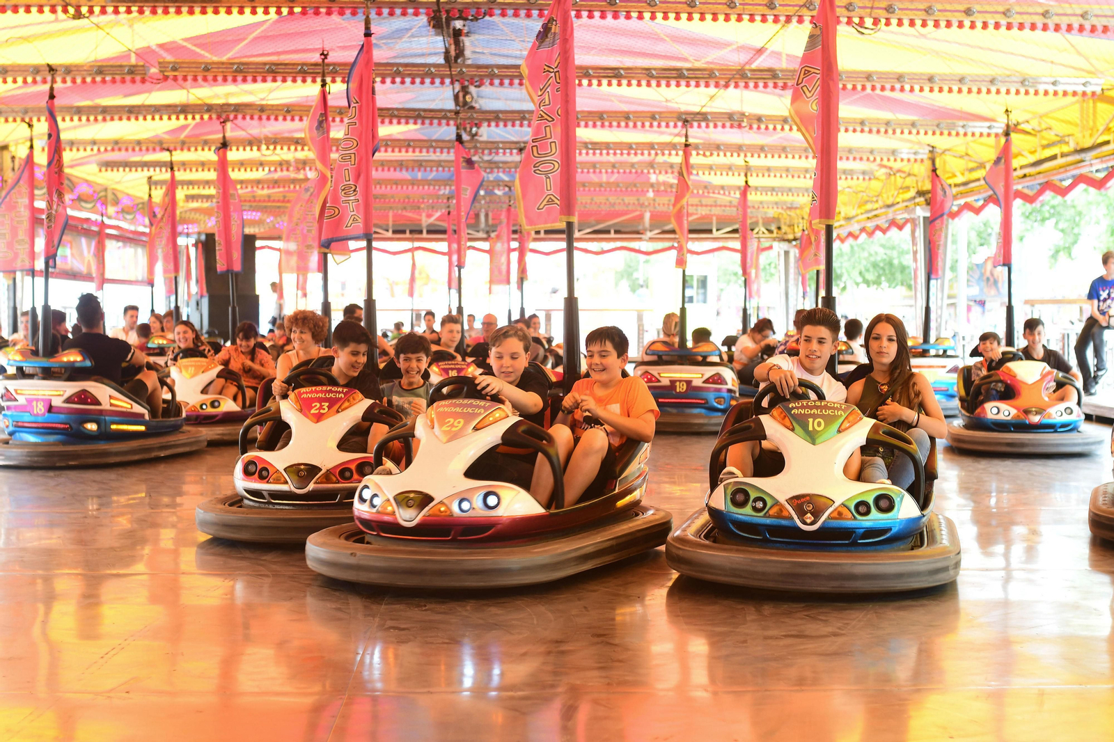 Un grupo de niños se divierte en la tradicional atracción de los coches de choque en la calle del Infierno.