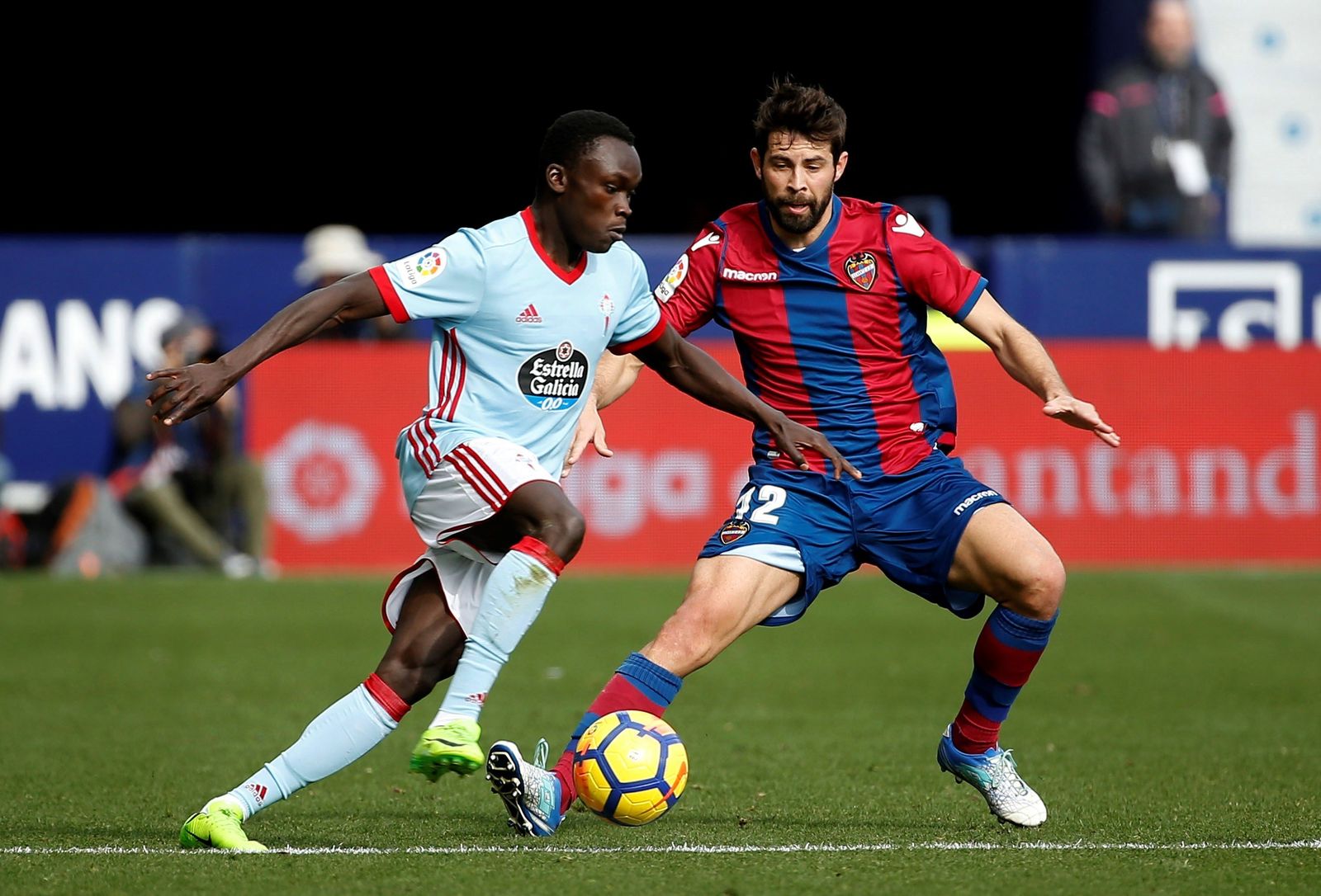 Pione Sisto intenta proseguir con el balón presionado por el levantinista Coke.