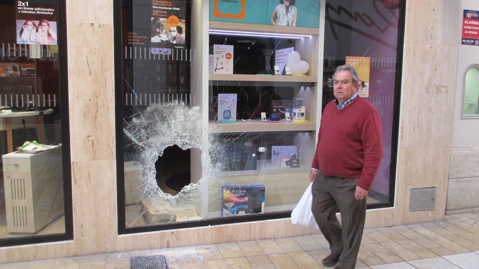 Agujero en el escaparate de una tienda de móviles de la calle Palacio de Huelva, en enero.