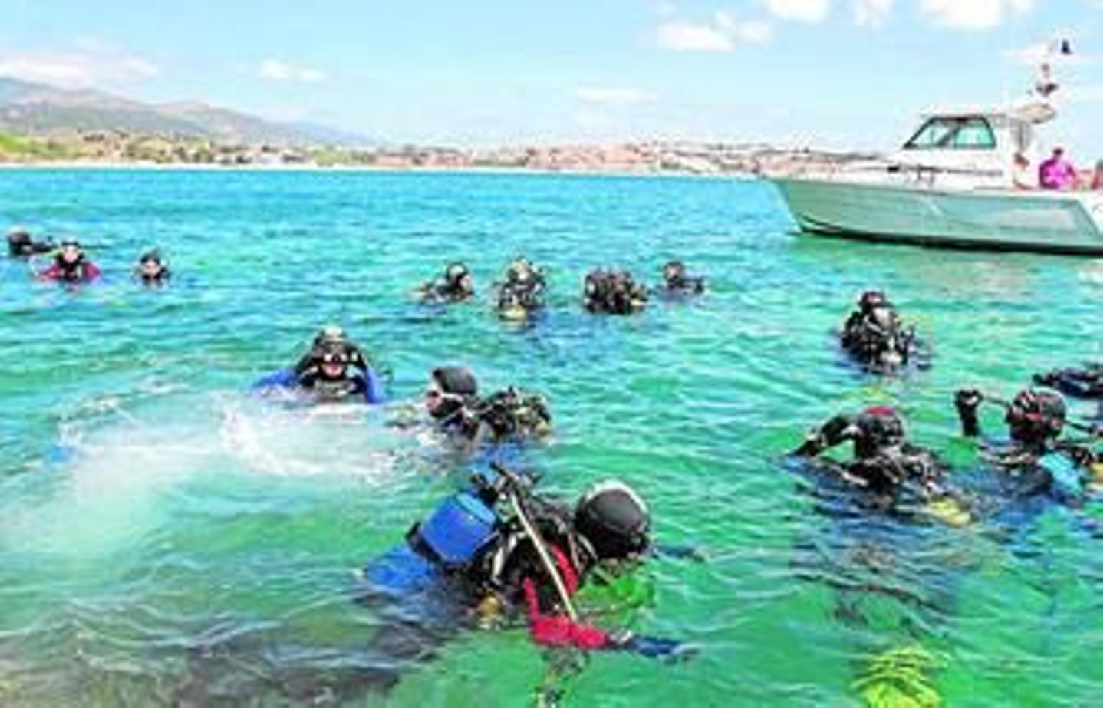 El grupo de buzos, ya en el agua para realizar la limpieza de los fondos marinos.