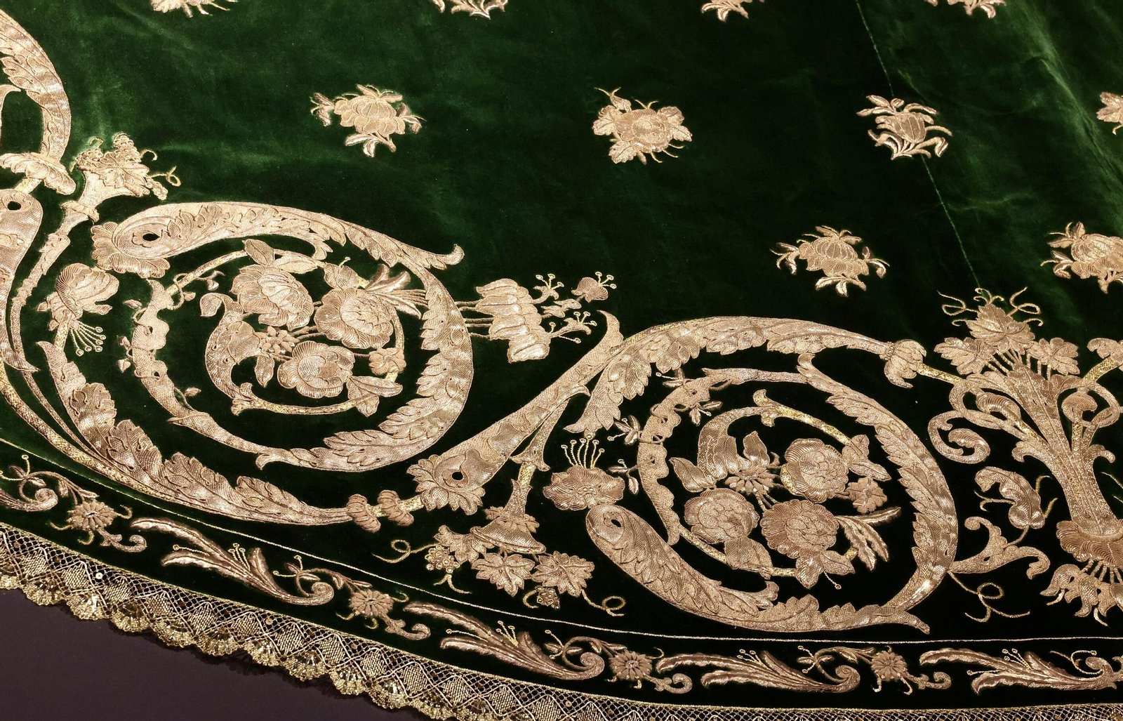 Detalle de la greca y el salpicado de flores que componen el manto de la Virgen de los Reyes. Detalle de la greca y el salpicado de flores que componen el manto de la Virgen de los Reyes.