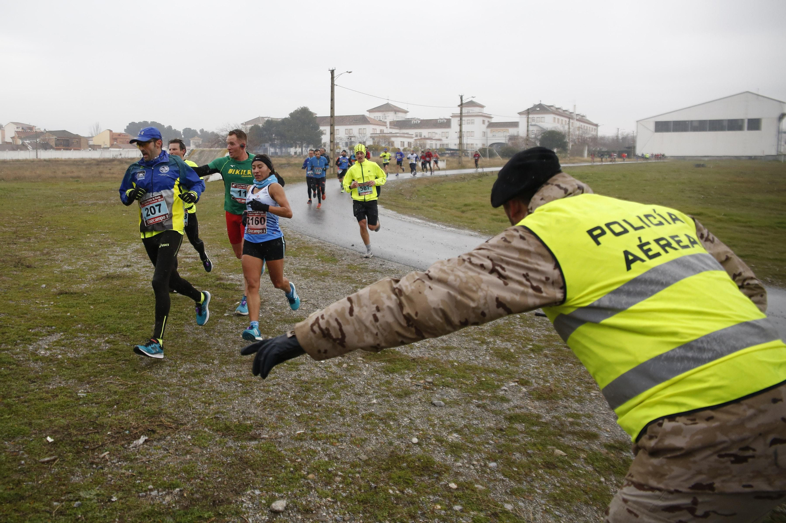 Un militar de la Base Aérea de Armilla indica el recorrido a los participantes.