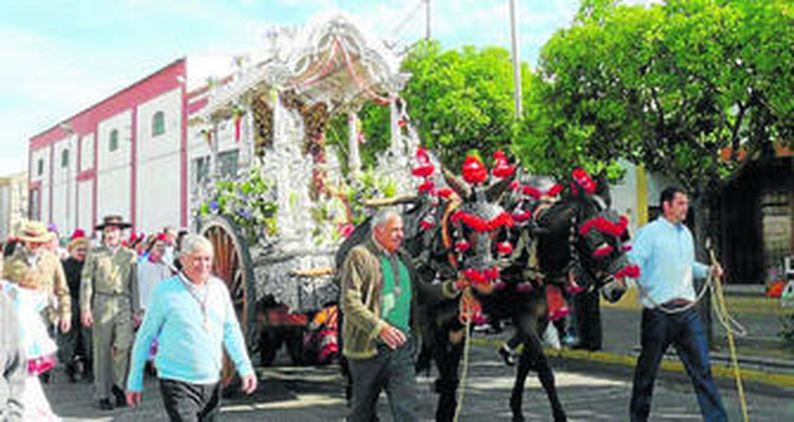 El Simpecado rocianero, tirado por mulos, ayer en la despedida de la localidad antes de poner rumbo a la aldea almonteña.