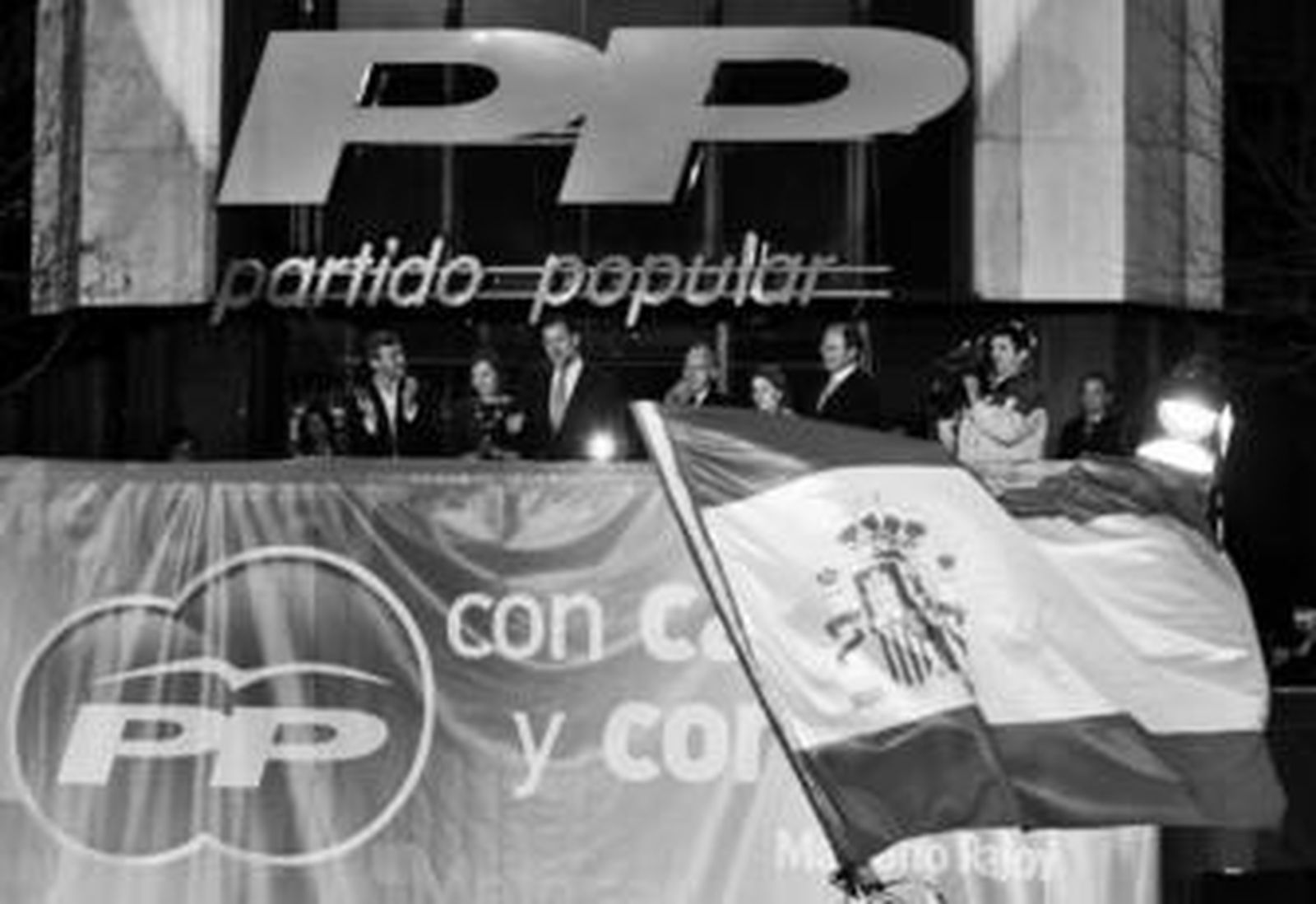 Rajoy saluda a sus simpatizantes junto a su mujer y a sus colaboradores durante la noche electoral.