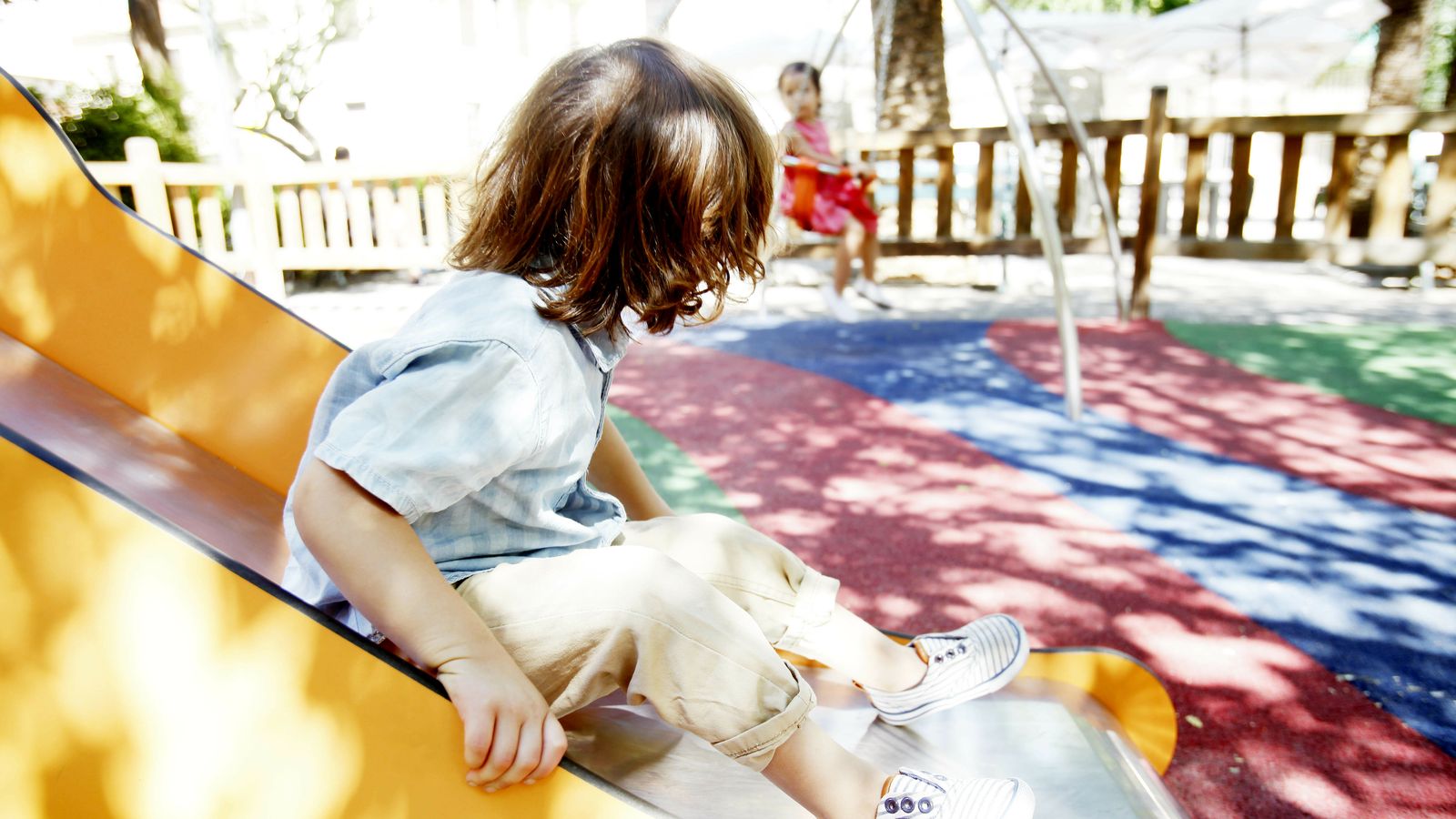 Un menor juega en el parque con una hermana no biológica, sino de acogida