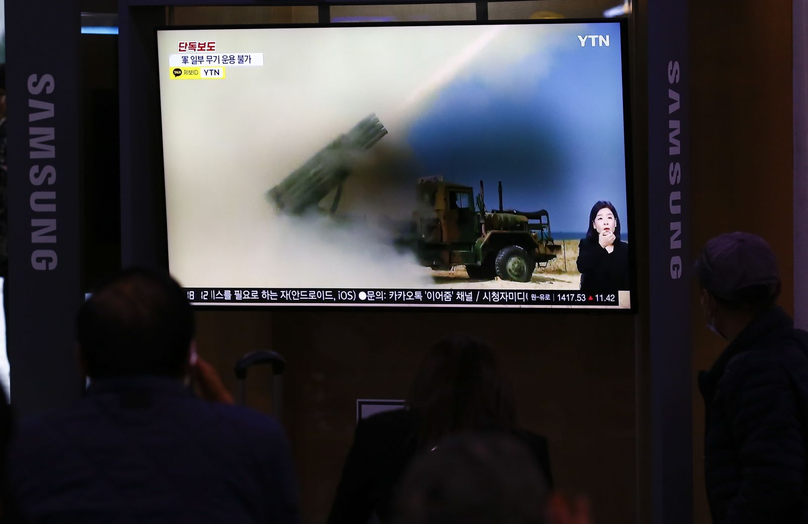 Varias personas observan las noticias en una estación de Seúl.