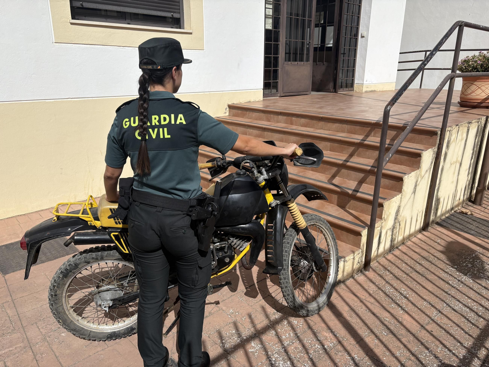 Una agente junto al ciclomotor
