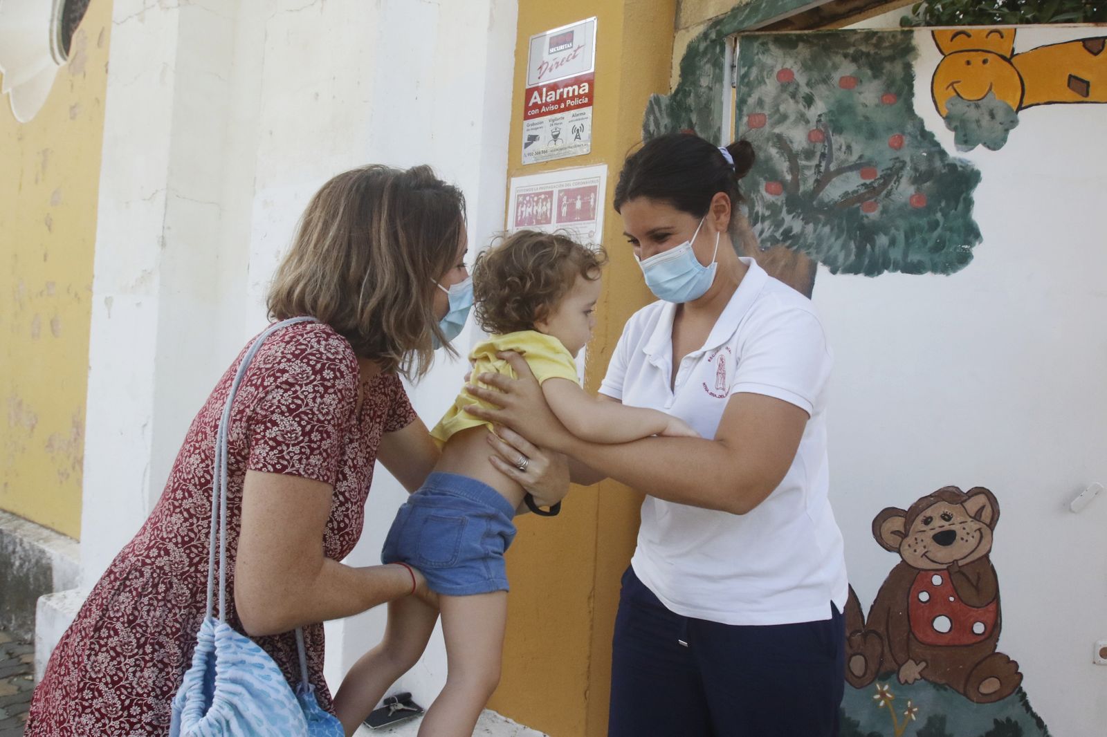 Una madre lleva a su pequeña a la guardería.
